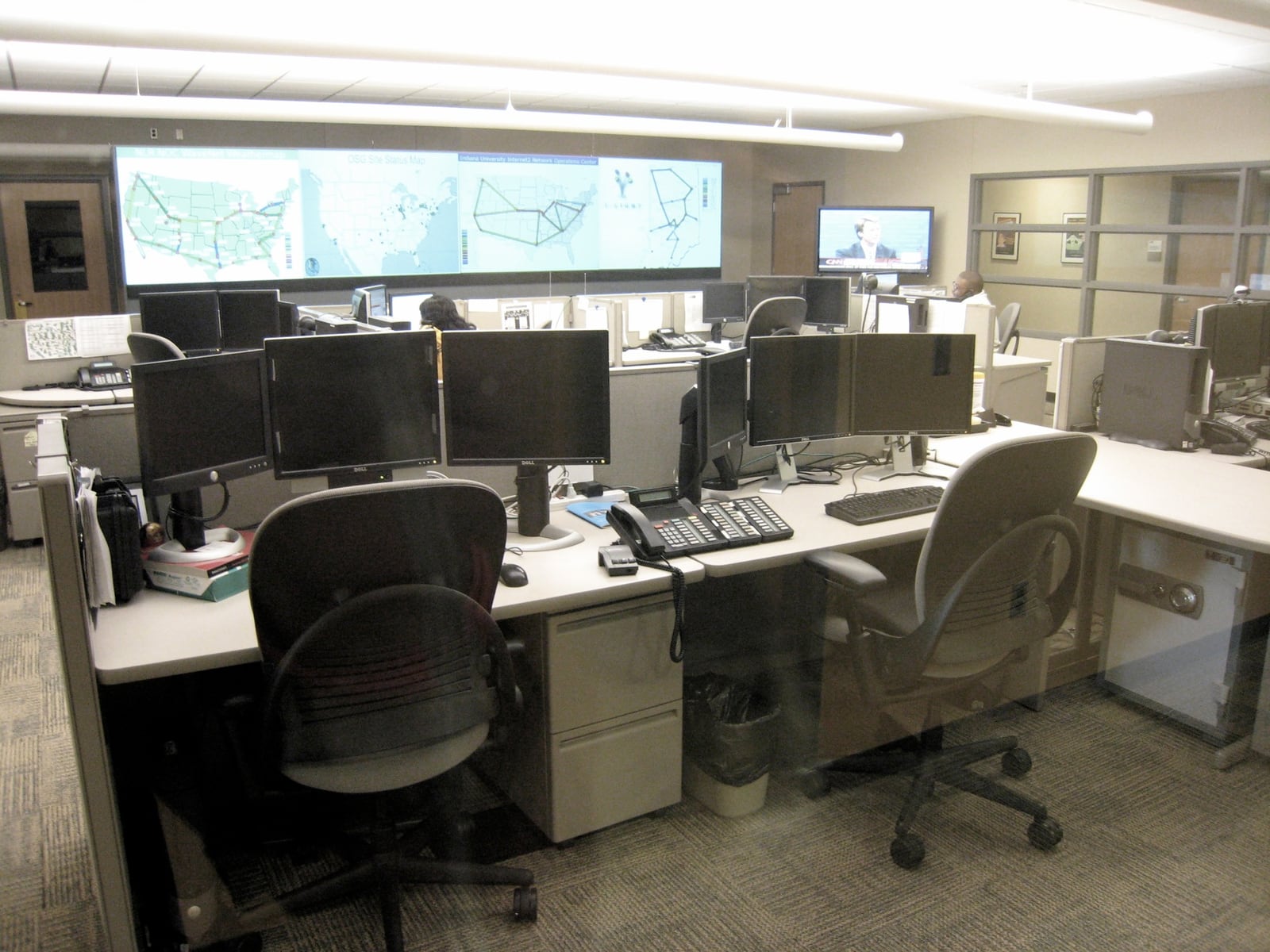 Network operations center with monitoring displays and operator workstations