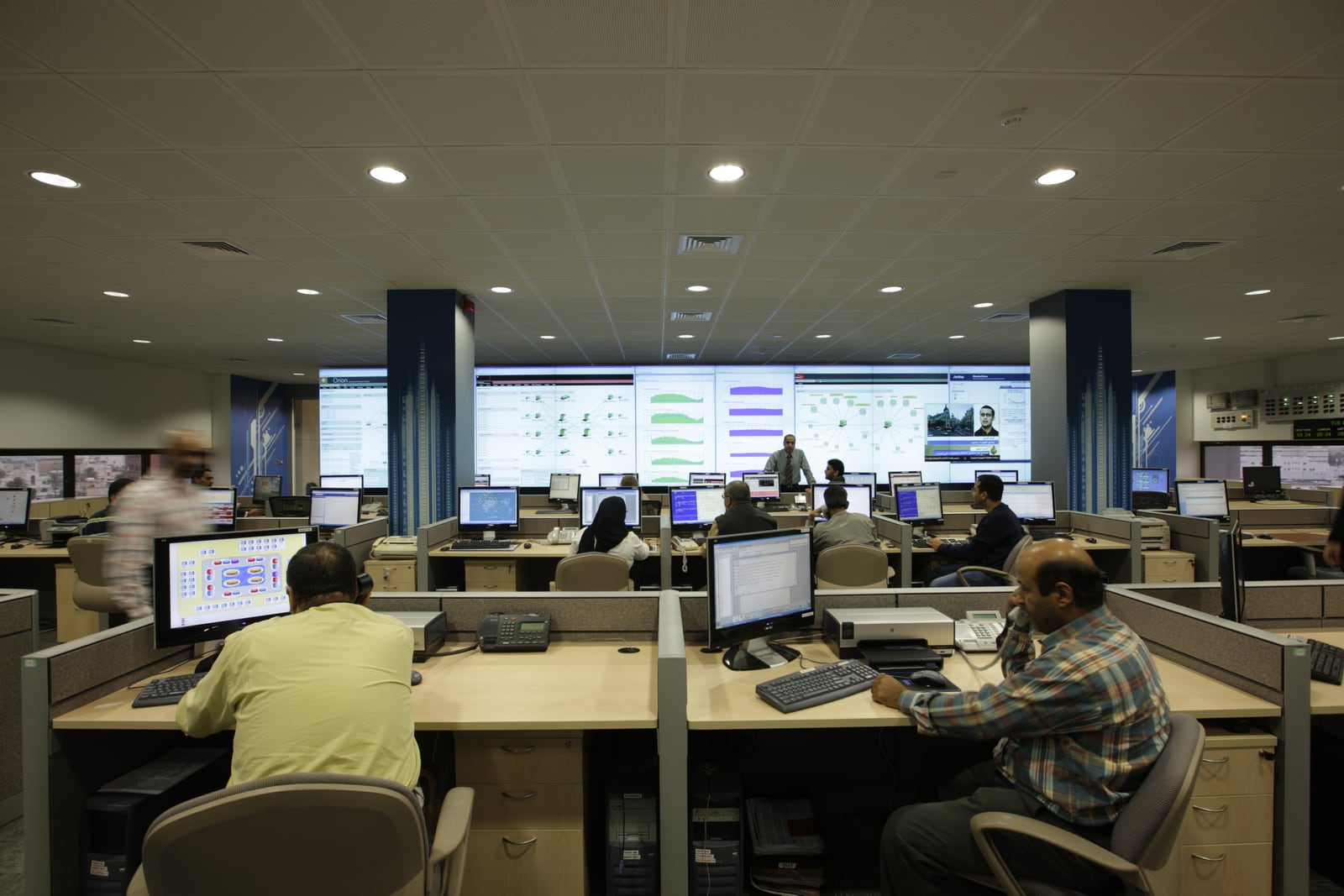 Engineers monitoring network and service dashboards in a network operations center