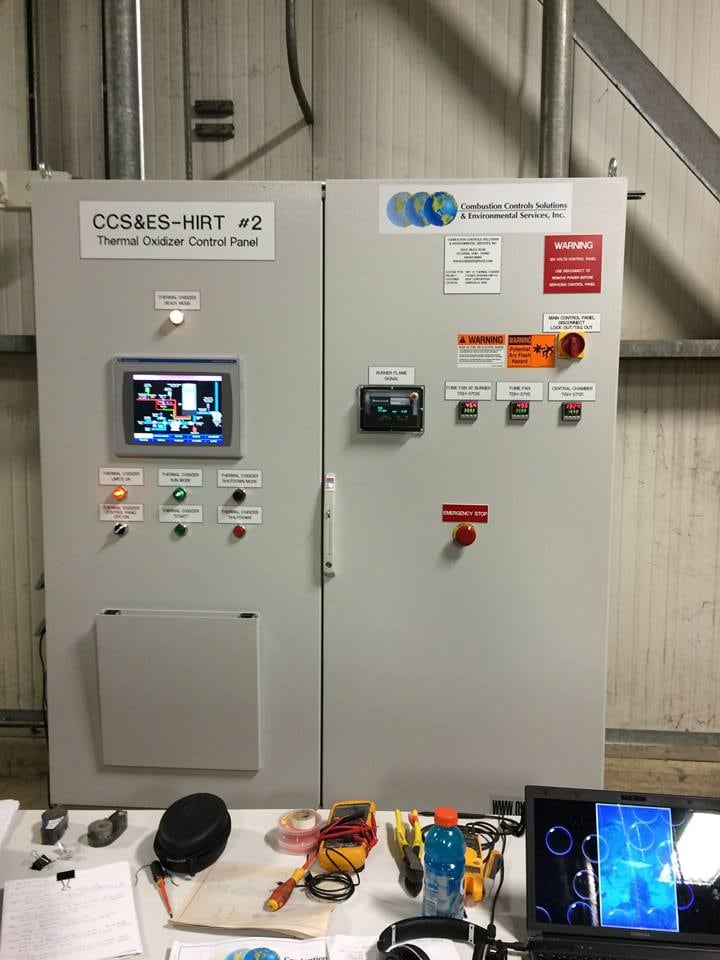 Industrial control cabinet with a PLC touchscreen, switches, indicator displays and emergency-stop controls