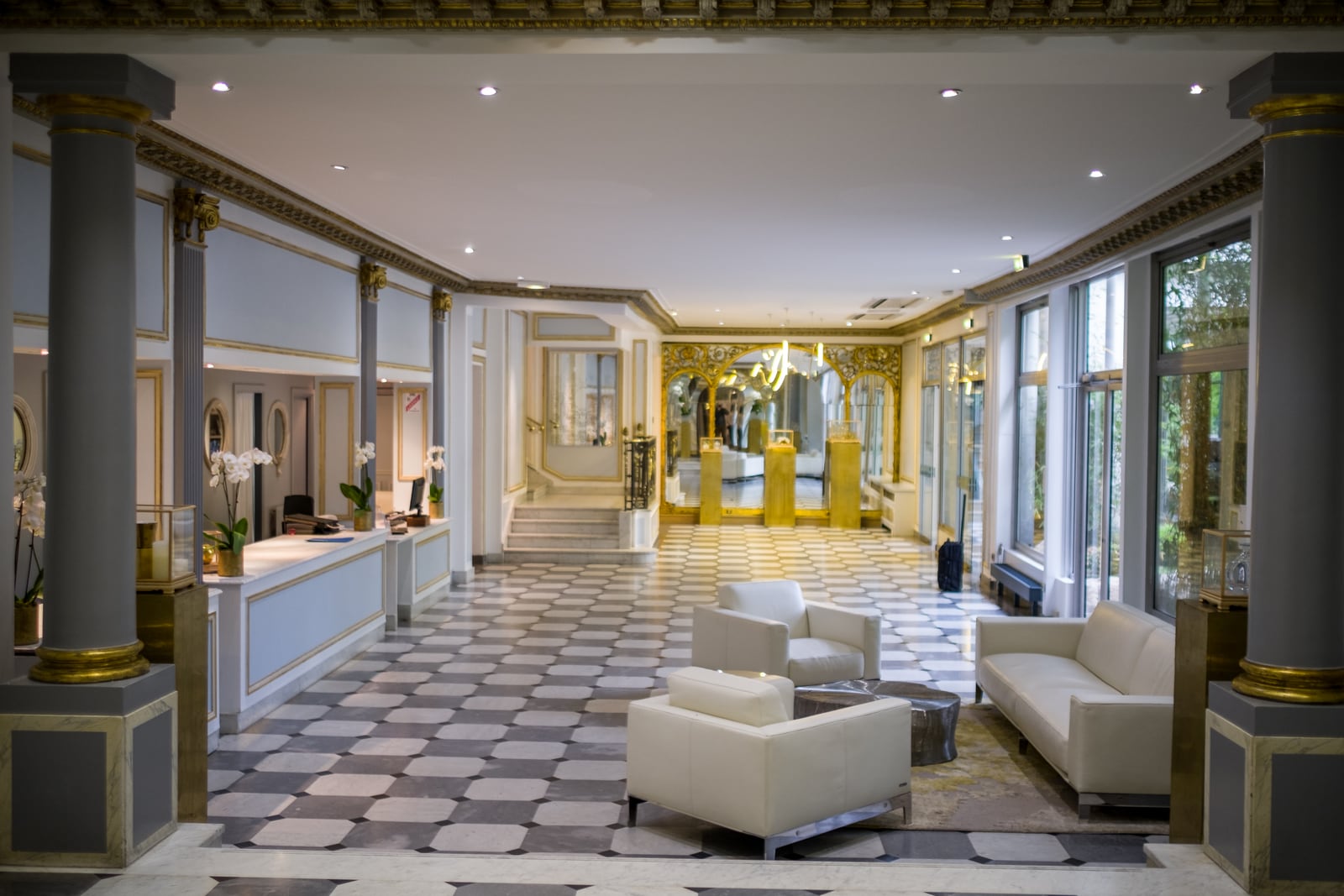 Hotel lobby with a reception desk, seating area and guest entrance