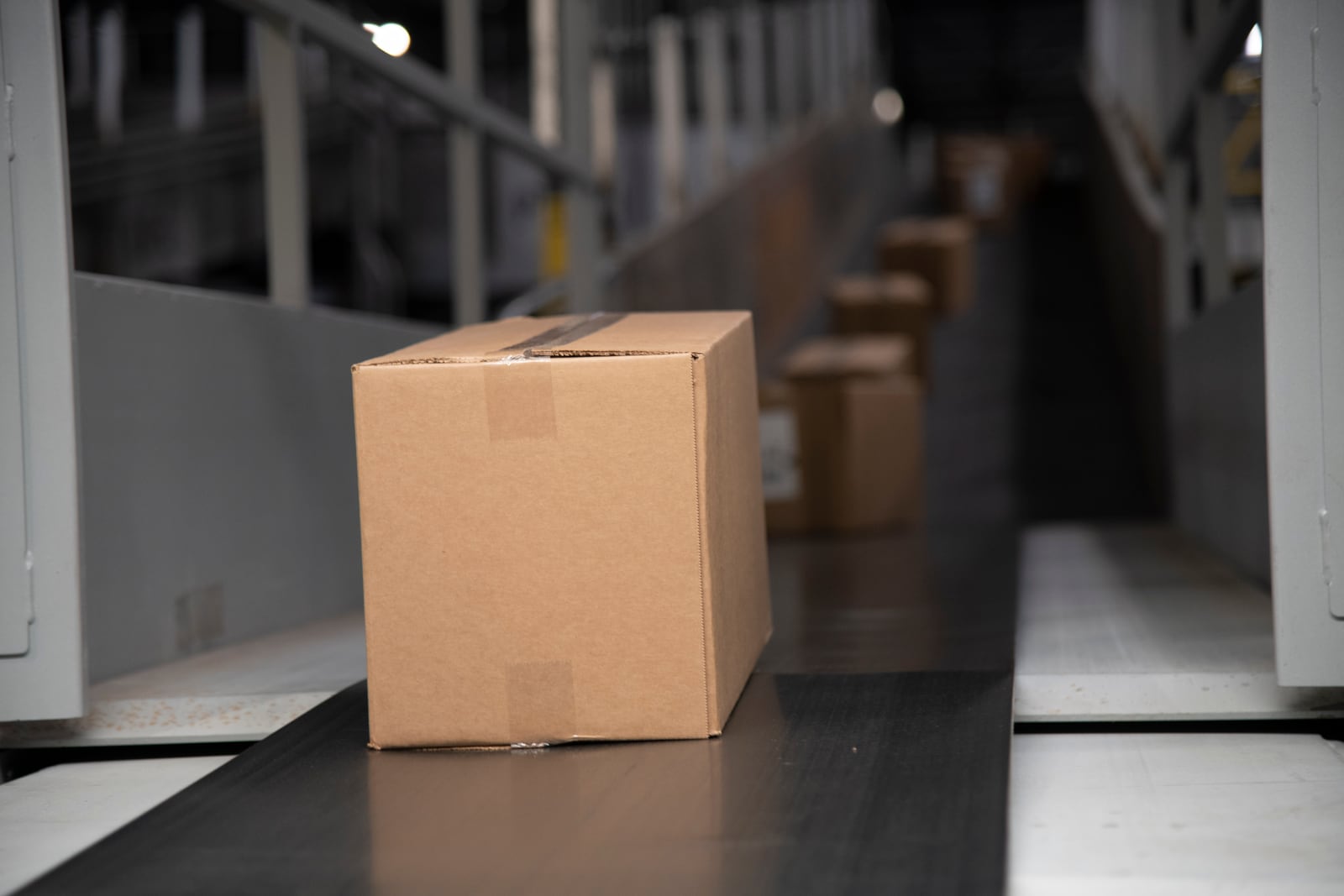Cardboard packages moving along a conveyor belt inside a distribution center