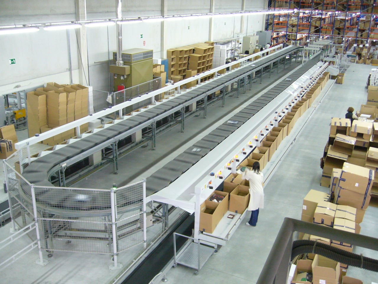 Cartons moving through an automated cross-belt sorting system in a warehouse