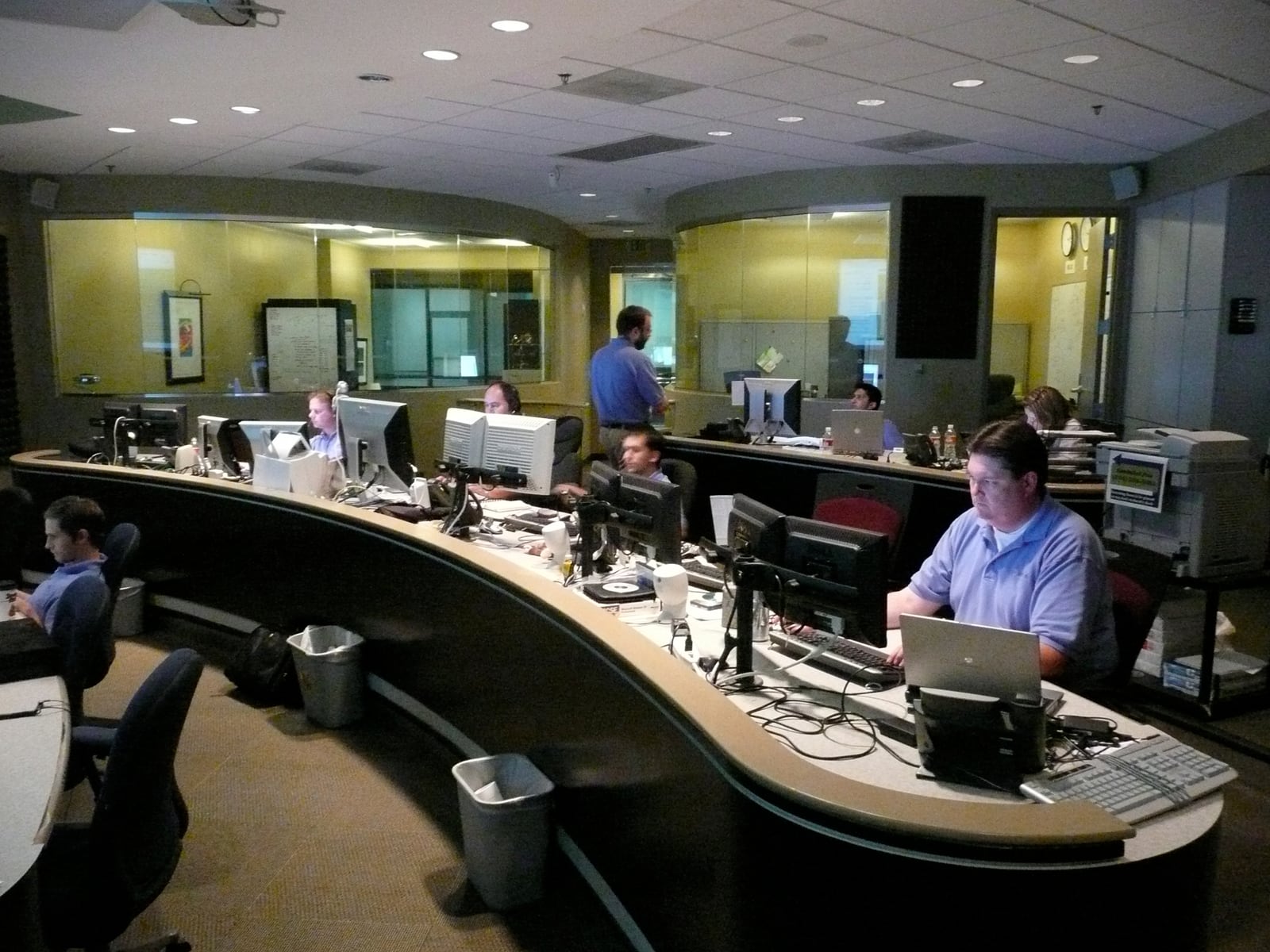Technicians working at monitoring desks inside a network operations center
