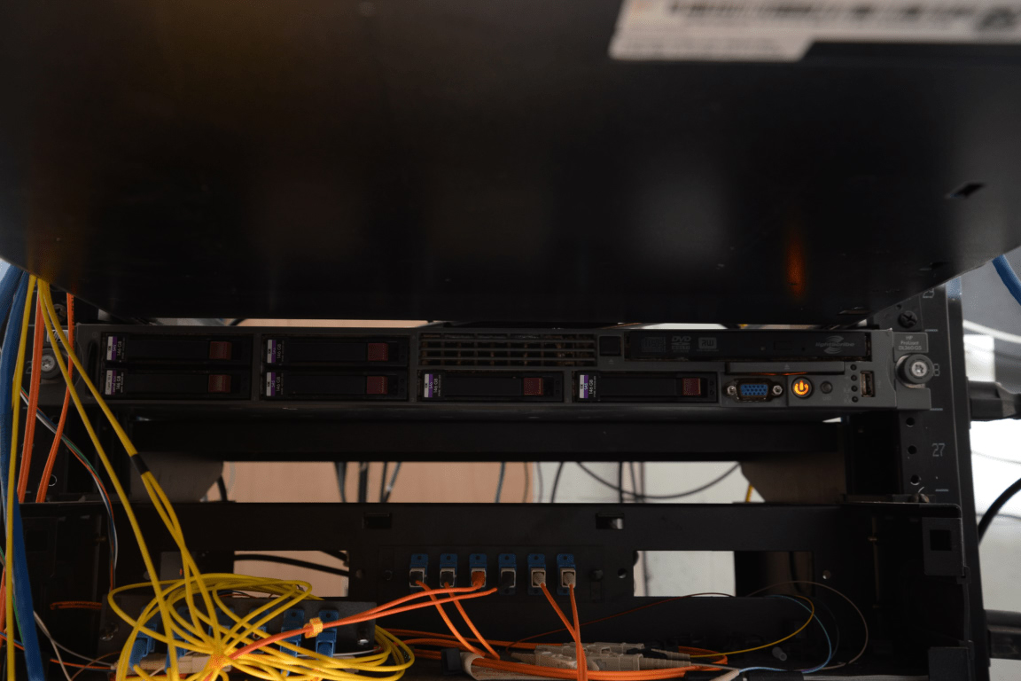 EFTA00002518 Server rack with multiple hard drives and network cables connected in a data center environment for cloud infrastructure, DevOps and platform engineering