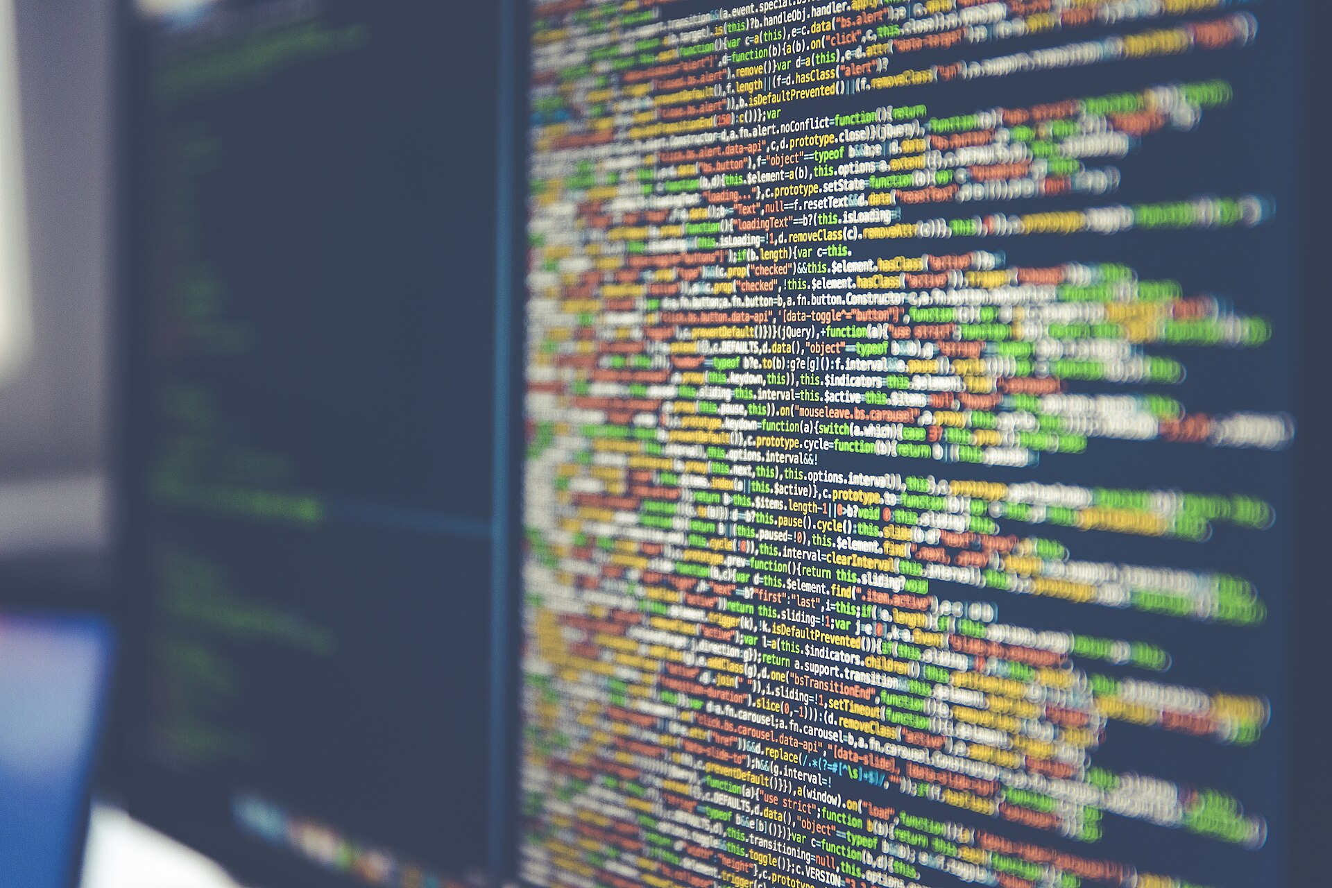 Code on computer monitor (Unsplash) for custom software and web application engineering