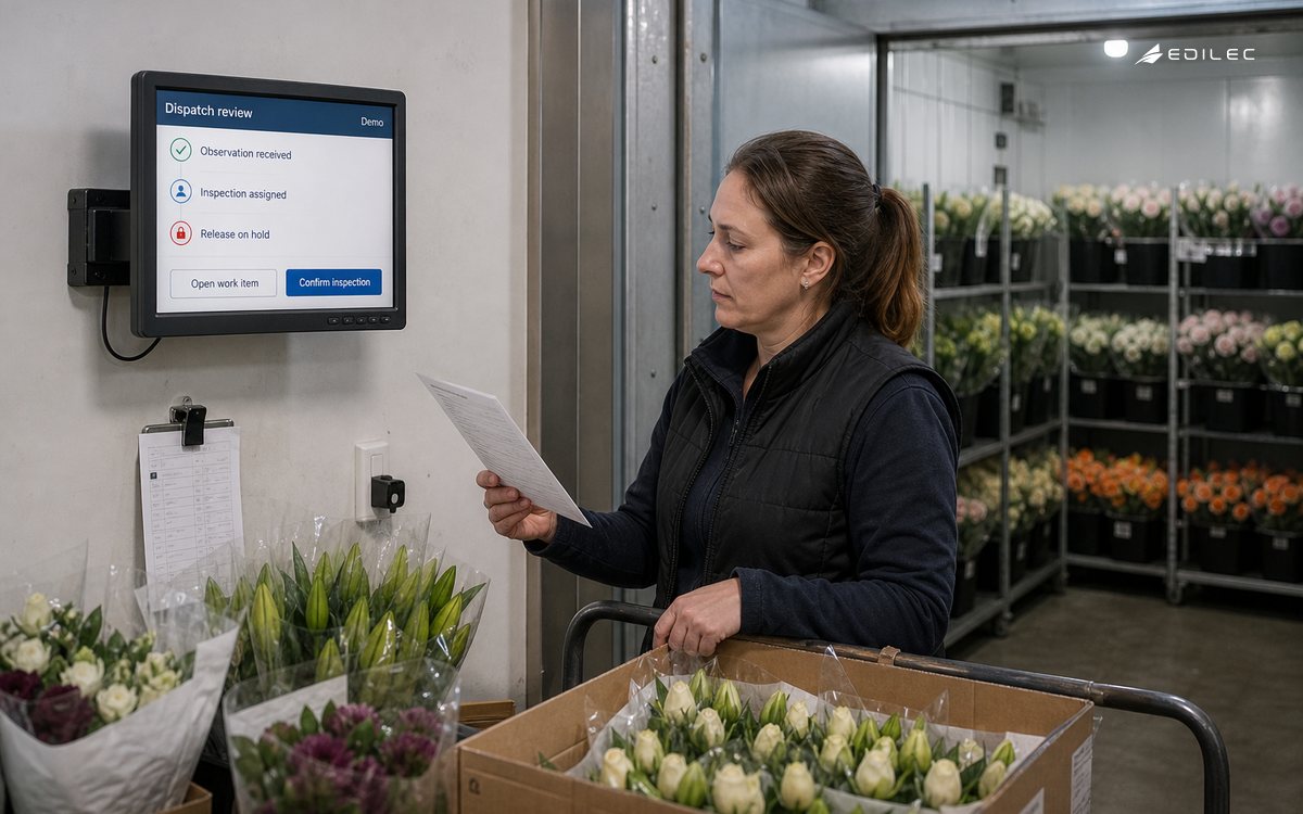 A florist dispatch supervisor checks an operational hold near a chilled flower store.