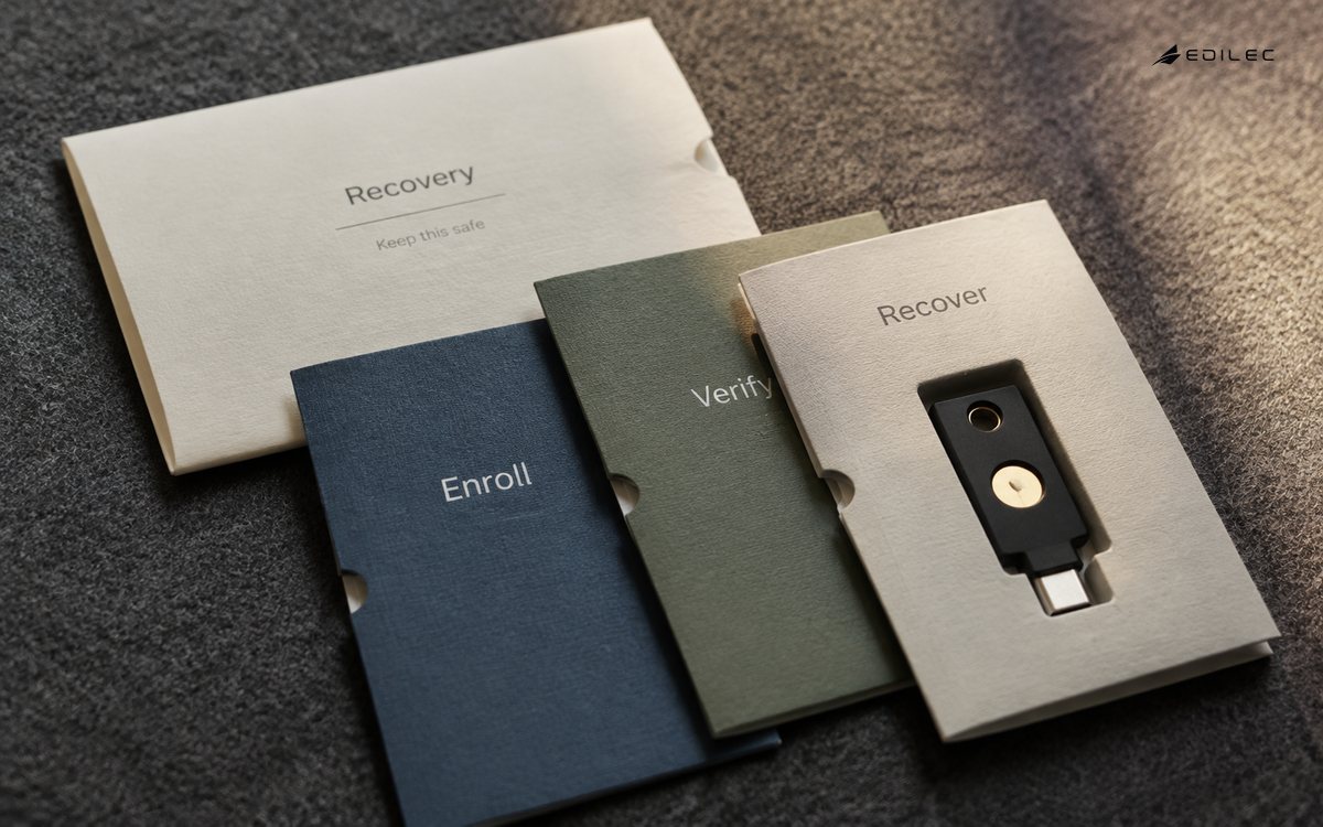 A security key, recovery envelope and enrollment cards form a physical onboarding kit.